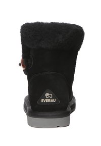Black suede ankle boots with a soft, textured fleece collar. Features a round heel and a logo patch on the back. Silver-toned hardware accents.