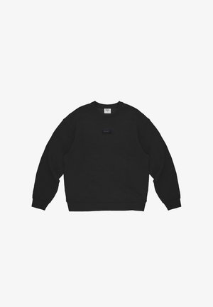 Czarna bluza z długim rękawem i okrągłym dekoltem, z ściągaczami na mankietach i u dołu, z małą prostokątną naszywką z logo na środku klatki piersiowej.