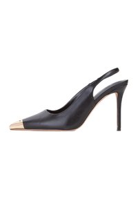 Zapato negro de tacón alto tipo slingback con puntera metálica dorada puntiaguda y tacón delgado en un fondo blanco.