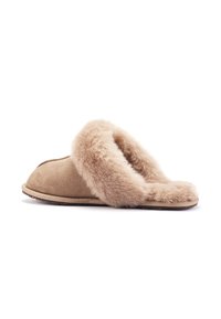 Beige suède pantoffel met een fluffy beige bontafwerking, open achterkant, en platte zool, die een gestructureerd oppervlak en een ronde neus heeft.