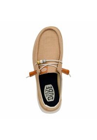 Scarpa slip-on in tela beige con punta rotonda e dettagli in elastico. Presenta una soletta imbottita e un accento in pelle marrone vicino al tallone.