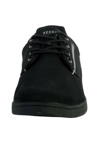 Zapatilla negra con acabado de gamuza. Presenta cordones planos, un collar acolchado y una suela de goma. Acentuada con un panel lateral gris.