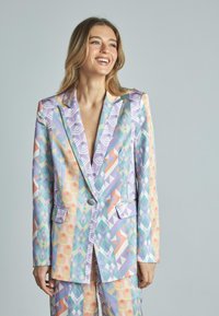 Blazer colorido con un patrón de diseños geométricos en tonos pastel, dos bolsillos frontales y cierre de un solo botón.