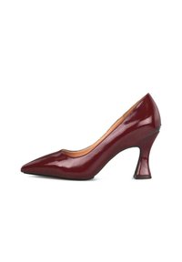 Zapato de tacón alto de charol burdeos con punta afilada y tacón en bloque de forma única.