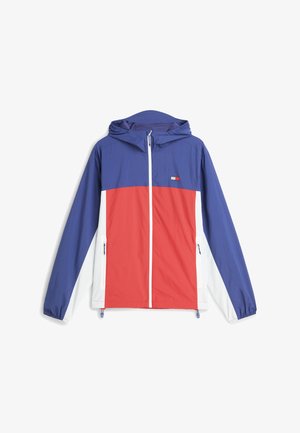 Veste à capuche zippée bleu, rouge et blanc avec poignets élastiques, poches avant et petit logo rectangulaire sur la poitrine.