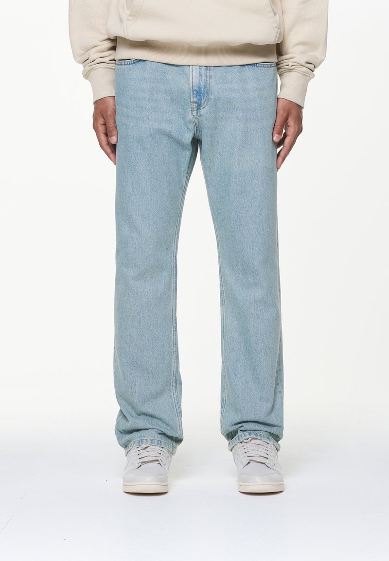 Lyseblå rette jeans, laget av denim materiale, med subtile slitasjemerker, lett falming, og en standard fem-lomme design. Kombinert med lyse sneakers.