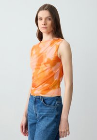 Mouwloos topje met abstracte patronen in oranje en roze, gemaakt van lichtgewicht stof, met een getailleerd ontwerp en geplooid detail aan de zijkant.