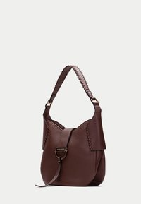 Bolso de mano de piel marrón con superficie texturizada, forma estilo sacó, correa de hombro trenzada y detalles de hardware en tono dorado.