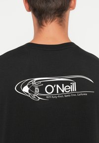 Sort bomulds t-shirt med et hvidt grafisk design af en surfer og tekst, der står "O'Neill" og "1071 Forty-First, Santa Cruz, Californien."