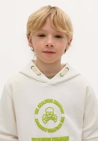 Witte hoodie met een groen skull en crossbones ontwerp, met gestructureerde borduursels, ronde halslijn en groene oogjes op de capuchon.