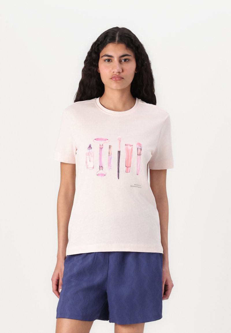 Lichtroze katoenen T-shirt met grafische illustraties van schoonheidsproducten in verschillende tinten roze. Korte mouwen, ronde halslijn.