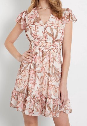 Sukienka w kwiaty z różowymi i brązowymi liśćmi, krótkimi falbaniastymi rękawkami, dekoltem w serek, marszczonym pasem i falbaną u dołu, noszona przez kobietę z ręką na biodrze.