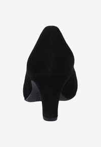 Chaussure à talon haut en daim noir avec un bout pointu et un talon carré court. La surface est lisse avec une texture douce et un minimum de détails.