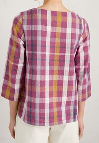 Cotton plaid top in shades of pink, yellow, and white, featuring a round neckline and three-quarter sleeves with a textured finish.