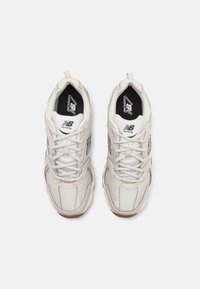 Weiße Netz- und synthetische Laufschuhe mit einer strukturierten Oberfläche, ausgestattet mit einer geschlossenen Zehe, Schnürsenkeln und schwarzen Polsterakzenten.