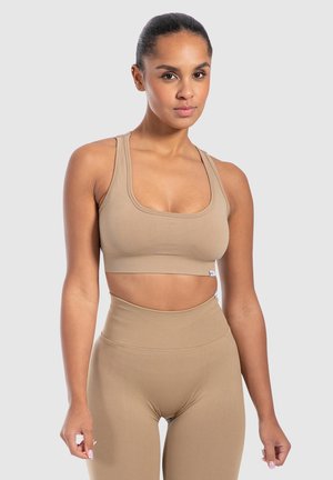 Tansportbeha met brede schouderbanden, een vierkante halslijn en een aansluitend ontwerp. Gecombineerd met hoge taille leggings in dezelfde stijl. Soepele textuur.