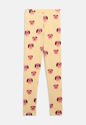 Leggings beige con un motivo ripetuto di piccole facce di cani rosa, alcune mostrano corpi interi e altre solo teste con orecchie flosce.