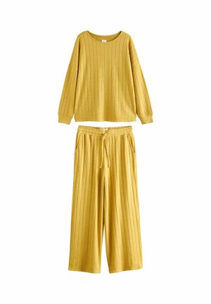 Žlutý loungewear set z hořčicové barvy obsahující žebrovaný dlouhý rukáv s kulatým výstřihem a kalhoty s širokými nohavicemi, elastickým pasem a kapsami.