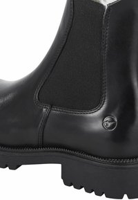 Schwarze Leder-Stiefelette mit einem strukturierten Elastikpanel, strapazierfähiger Gummisohle und einem kleinen Logo-Akzent an der Seite.