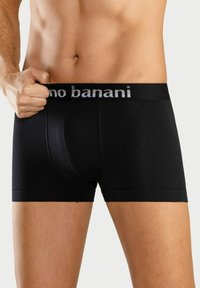 Black boxer shorts made of soft material with a snug fit. Features a grey waistband with the brand name displayed prominently.