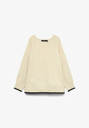 Suéter de manga larga color crema con escote en V y ribete negro en los puños y el dobladillo, colocado sobre un fondo blanco.