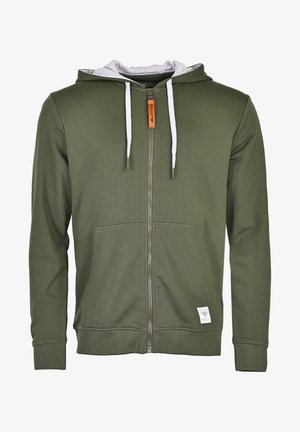 Oliwkowy hoodie na zamek z szarym wykończeniem kaptura, białymi sznurkami, kieszeniami z przodu i małą metką z logo na dole. Miękki materiał.