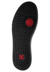 Suola in gomma nera con motivo di presa testurizzato; presenta un accento circolare rosso e logo. Design elegante e piatto, adatto per calzature casual.