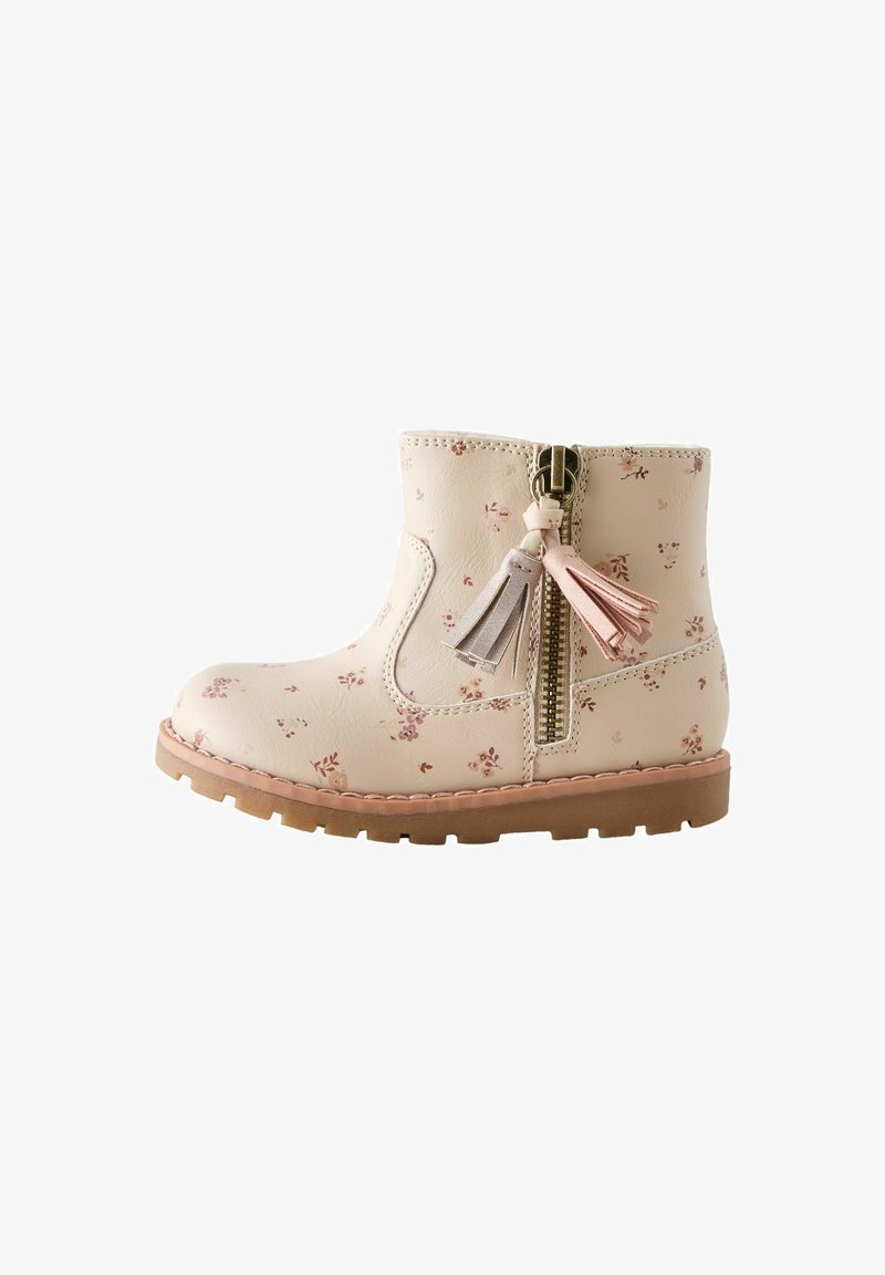 Licht beige kinderschoenen met kleine roze bloemenprints, een zijrits en twee kwastjes aan de ritssluiting, cognackleurige rubberen zool.
