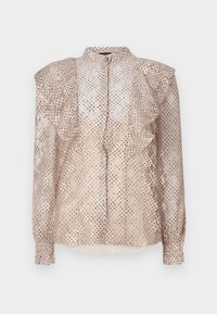 Beige paita, jossa on pilkullinen kuosi, rypytetyt olkapäät ja pitkät hihat. Siinä on napitettava etuosa ja kevyt, läpikuultava kangas.