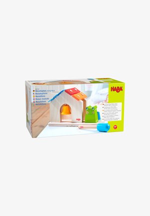 Maison de jouet en bois avec toit métallophone, cloche orange, figurine de grenouille verte et maillet bleu, emballée dans une boîte de la marque HABA pour les enfants dès 1 an.