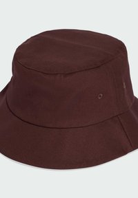 Brauner Bucket Hat mit flachem Oberteil, breiter Krempe und genähten Details. Aus robustem Stoff gefertigt, mit Belüftungsöffnungen an den Seiten.
