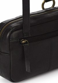 Bolso de cuero negro con un compartimento con cremallera, herrajes en tono dorado, una correa desmontable y una textura suave con detalles de costura.