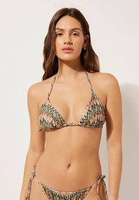 Due pezzi bikini con un vivace motivo a zigzag, coppe a triangolo e slip con laccetti ai lati, dotati di un anello metallico al centro.