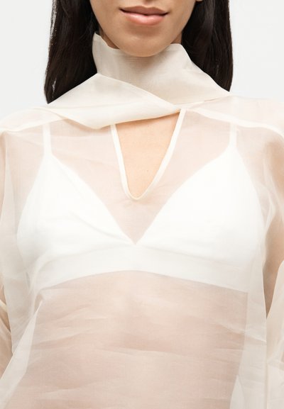 Διάφανη, ελαφριά μπλούζα από ύφασμα με υψηλό γιακά και βαθύ V-λαιμόκοψη. Σχεδιασμός με στρώσεις σε παστέλ αποχρώσεις, αποκαλύπτοντας ένα λευκό εσώρουχο από κάτω.