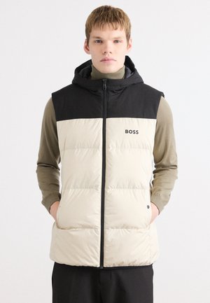 Puffer vest with a black hood and upper section, cream lower section, featuring a front zipper, two side pockets, and a logo on the chest.