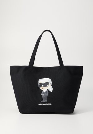 Fekete vászontáska, melyen napszemüveget viselő, öltönyös rajzfilmfigura grafikája látható, alatta a "KARL LAGERFELD" felirattal.