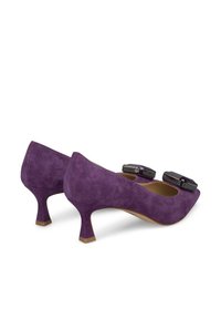 Scarpe cuoio scamosciato viola con tacco alto a punta di 5 cm, caratterizzate da due dettagli decorativi neri nella parte anteriore.