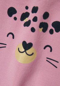 Tela rosa con la cara de un animal de dibujos animados que tiene manchas negras, un hocico dorado y bigotes negros. Textura suave con detalles impresos.