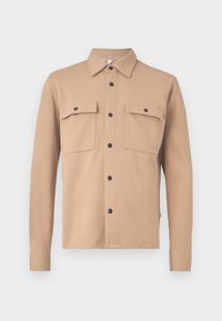 Giacca camicia beige con maniche lunghe, colletto a punta, bottoni a pressione neri lungo la parte anteriore e su due tasche sul petto con bottone.