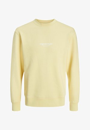 Sudadera de cuello redondo de manga larga en amarillo claro con el texto blanco "Originals Studio" impreso en el pecho.