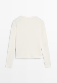 Langærmet skjorte i off-white bomuld med rund halsudskæring, tætsiddende design og en simpel, glat tekstur uden synlige mønstre eller accenter.