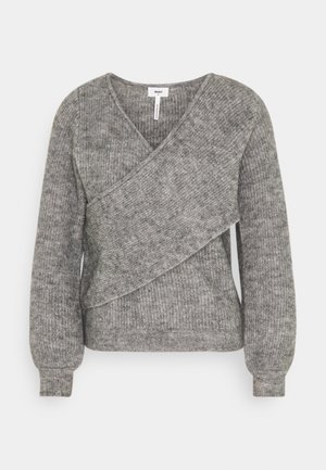 Pull gris à manches longues en tricot avec motif côtelé diagonal superposé sur le devant et poignets côtelés.