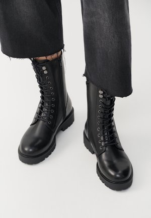 Black ankle boots featuring a smooth leather finish, lace-up front, and side zipper. Chunky sole and detailed eyelets add texture.