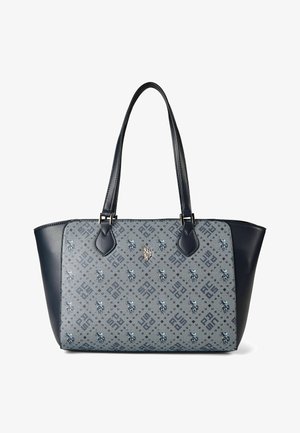 Bolsa tote azul con panel frontal de tela estampada que presenta diseños geométricos y florales, y asas y lados de cuero oscuro.