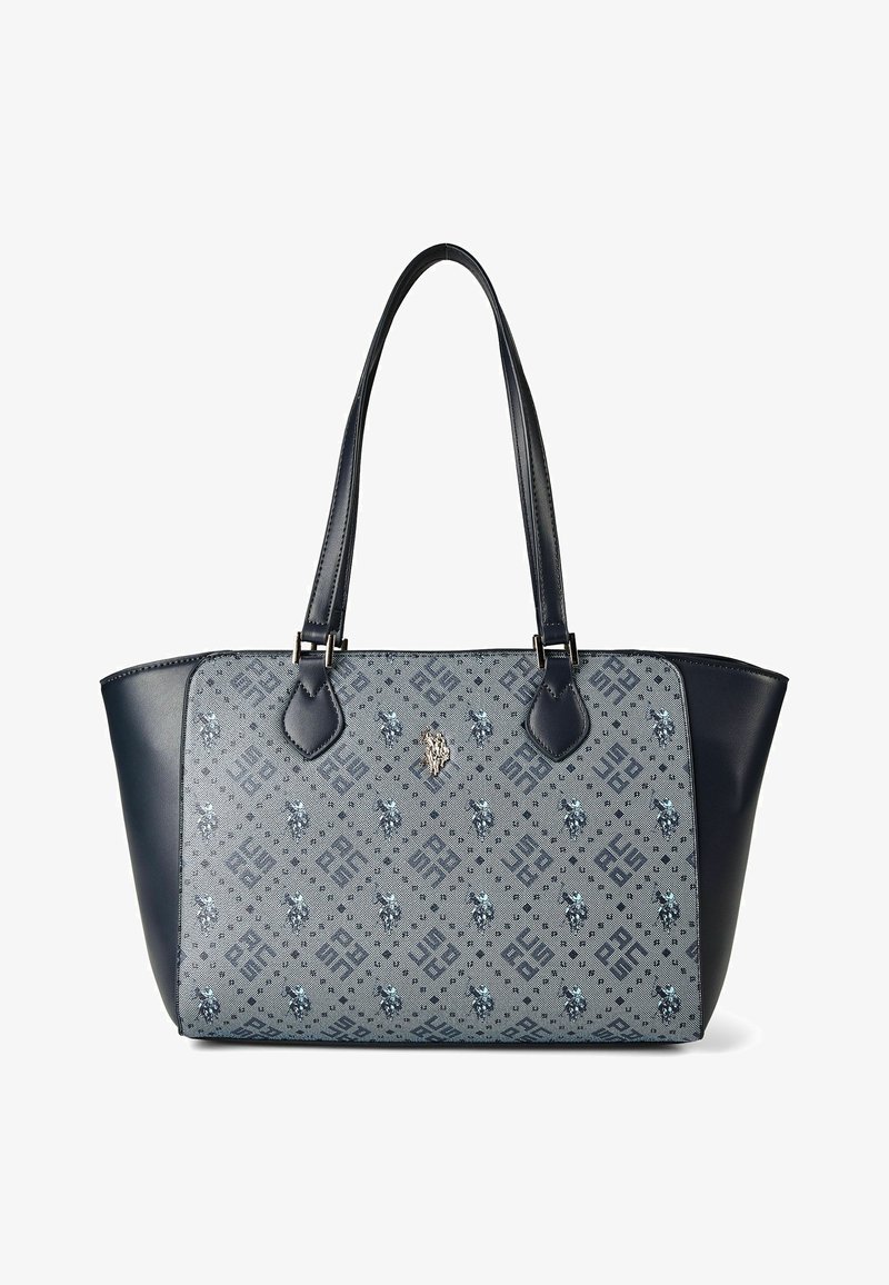 Bolsa tote azul con panel frontal de tela estampada que presenta diseños geométricos y florales, y asas y lados de cuero oscuro.