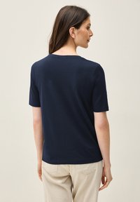 Mörkblå T-shirt med kort ärm och rund halsringning, tillverkad av mjuk tyg. Enkel design, med avslappnad passform och inga synliga mönster.