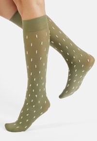 Olive green knee-high socks with a smooth texture, featuring white sporadic patterns and a ribbed cuff at the top.