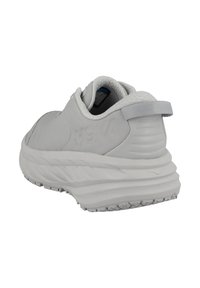 Šedá sportovní bota s texturovaným svrškem, polstrovaným límcem a očkem na patě. Má silnou gumovou podrážku s protiskluzovými vzory a bez viditelných tkaniček.