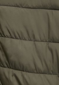 Close-up of padded olive green fabric with horizontal quilting and subtle grid texture.