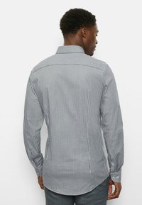 Langärmliges Hemd mit einem marineblauen und weißen vertikalen Streifenmuster, Button-Down-Kragen und abgerundetem Saum mit glatter Stoffstruktur.